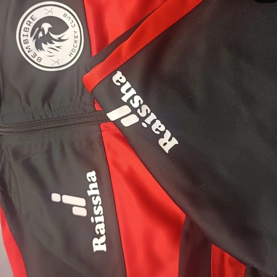 chándal con nombre Parte de una prenda deportiva con logotipos personalizados en colores negro y rojo.